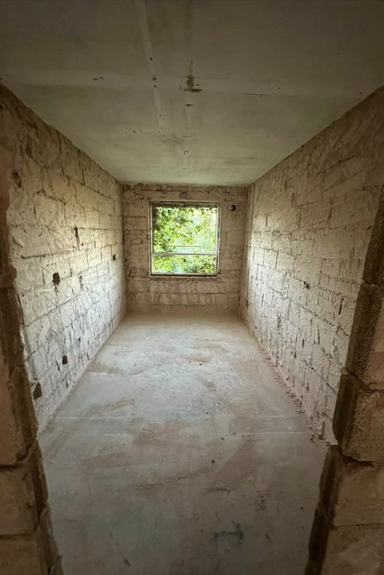After: room stripped back to bare brick and swept