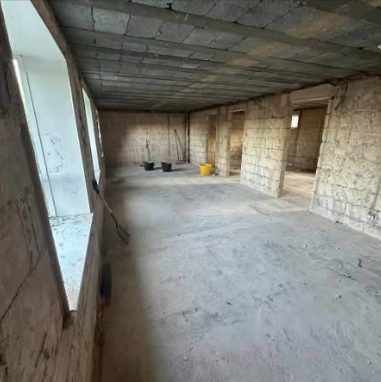 After: open-plan area stripped back to block walls