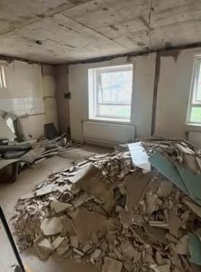 Before: room full of ceiling debris and broken boards