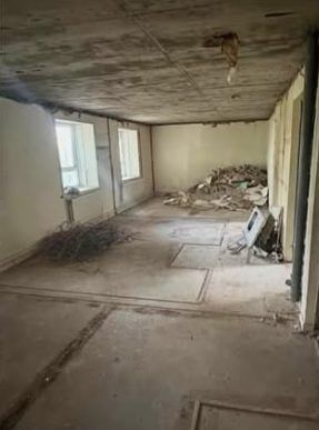 Before: open-plan room with rubble piled against the wall
